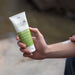 Good Riddance Tropical 100ml tube held while applying cream to an arm